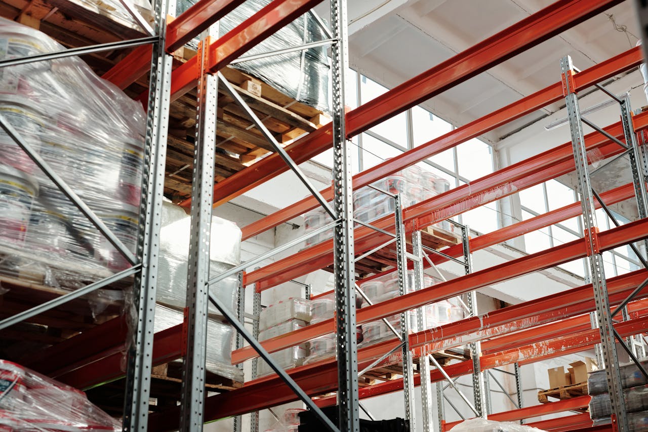 about-01 Bright modern warehouse featuring pallets and storage racks for logistics and inventory management.