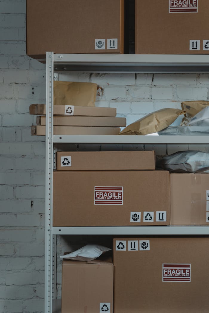 gallery-1 Organized cardboard boxes labeled 'Fragile' in warehouse setting for shipping and logistics.